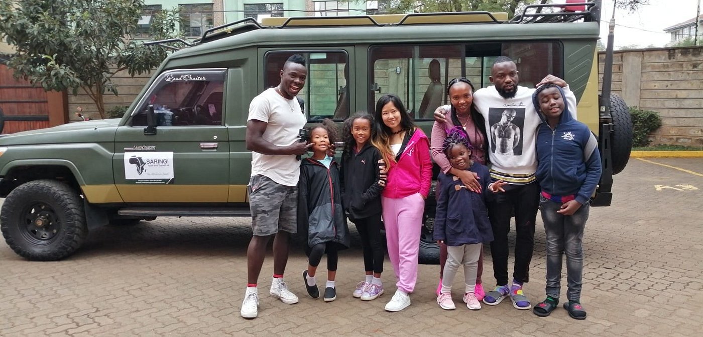 Family group with Saringi Tours vehicle, Maasai Mara
