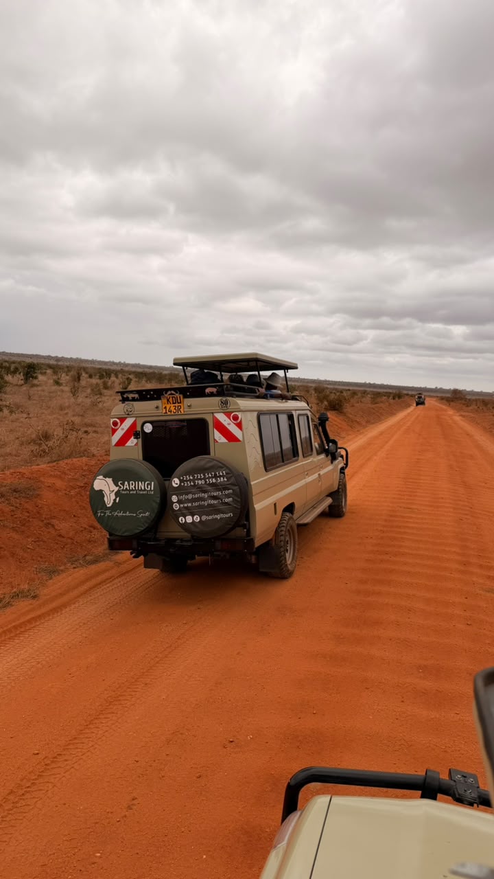Saringi Tours safari vehicle on a red track across the Tsavo East plains